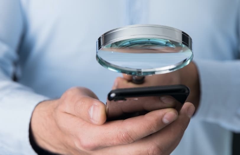 Using a magnifying glass to see a phone in relation to macular eye degeneration